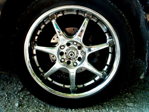 1995 Ford Probe - Close-up of a shiny chrome wheel and tire, with a brake rotor visible behind the spokes.
