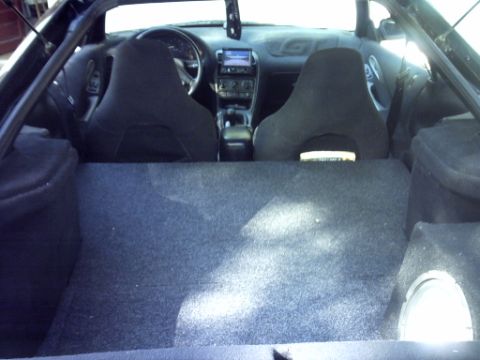 1995 Ford Probe - The interior of a car is shown, including the dashboard, seats, and a custom subwoofer enclosure in the cargo area.