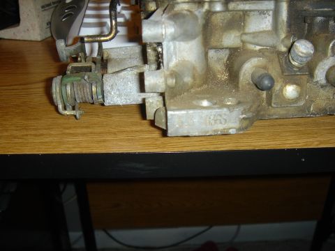 1986 Ford Mustang - Carburetor part with stamped markings, likely from an older vehicle.