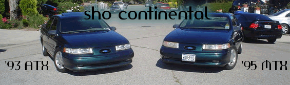 Two dark green Ford Taurus sedans parked on pavement. One is labeled '93 ATX, the other '95 ATX