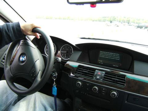 1998 Ford Taurus - Interior view of a BMW, showing the steering wheel, dashboard, and a warning message on the infotainment screen.