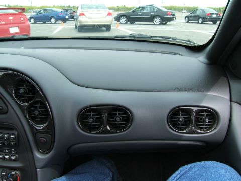 1998 Ford Taurus - The interior dashboard features distinctive oval air vents and an 'AIRBAG' indicator, with other vehicles visible through the windshield.