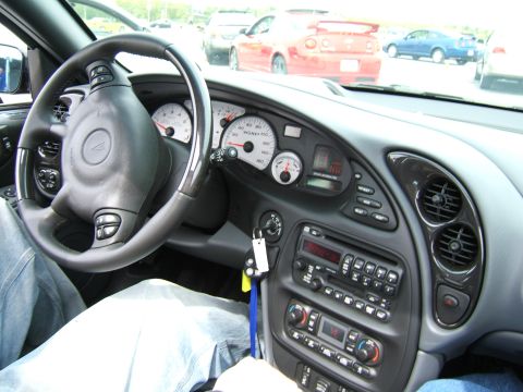 1998 Ford Taurus - Dashboard and interior of a 2004 Pontiac Grand Prix GXP, with other vehicles seen through the windshield.