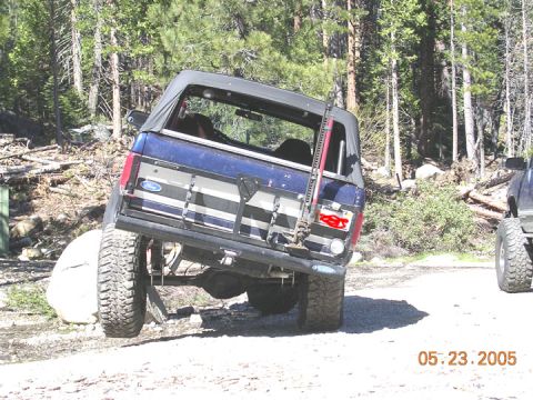 1994 Ford Bronco - This Ford Bronco is off-roading on a dirt path surrounded by trees.