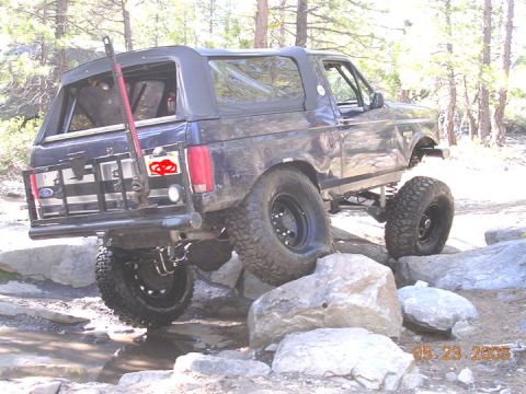 1994 Ford Bronco - This modified Ford Bronco navigates a rocky trail, showing its off-road capabilities.
