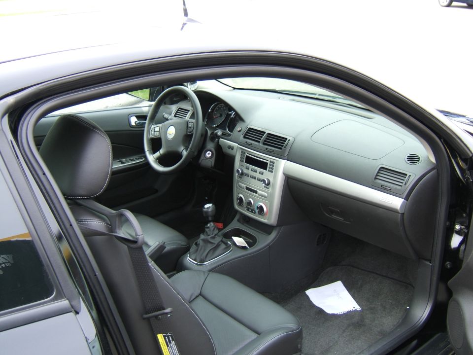 Car interior shot showing dashboard, steering wheel, seats, and center console