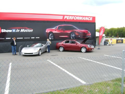 1998 Ford Taurus - Two cars are displayed at an outdoor event with a large "PERFORMANCE" banner in the background.
