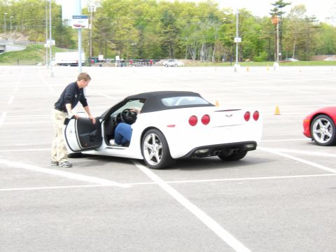 1998 Ford Taurus - A white convertible sports car is parked in a lot with its driver's door open, while another red sports car is visible nearby.