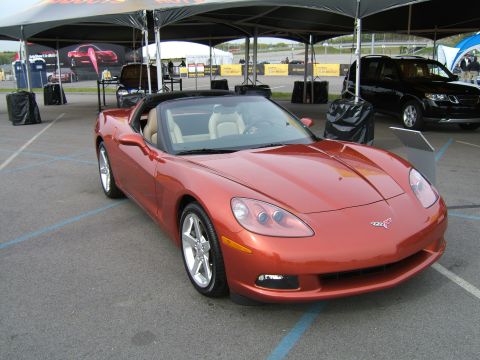 1998 Ford Taurus - Orange convertible sports car with tan interior is parked outdoors under a tent.