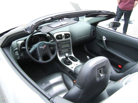 1998 Ford Taurus - The interior of a convertible Corvette shows black leather seats, a manual transmission, and the 'Corvette' script on the dashboard.