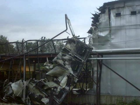 1995 Ford Bronco - The aftermath of a fire shows significant structural damage to an industrial facility and scattered debris.