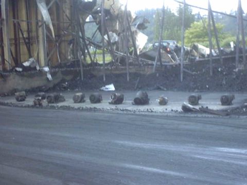 1995 Ford Bronco - The aftermath of a fire shows a collapsed structure and debris, with several objects lined up on the pavement.