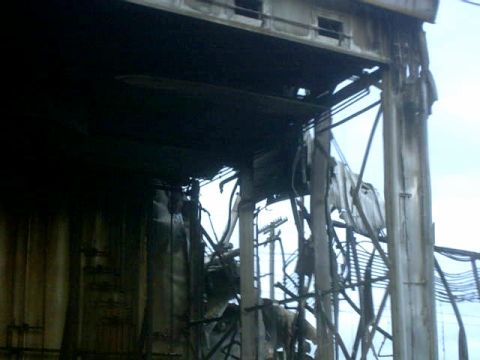 1995 Ford Bronco - Exterior view of a severely damaged industrial structure with visible structural damage and debris.