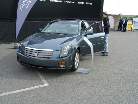 1998 Ford Taurus - A gray Cadillac CTS is displayed with its driver's door open, parked on asphalt.