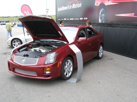1998 Ford Taurus - A red Cadillac sedan is displayed with its hood open, revealing the engine compartment.