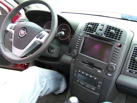 1998 Ford Taurus - The interior of a Cadillac features a leather-wrapped steering wheel and a central infotainment display.
