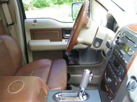 2005 Ford F-150 - The interior of a 2005 Ford F-150 features leather seats and wood trim accents on the dashboard and console.