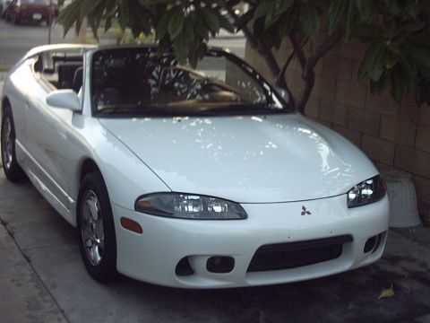 1998 Mitsubishi Eclipse - This white 1998 Mitsubishi Eclipse convertible is parked outdoors, partially shaded by a tree.