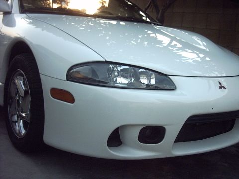 1998 Mitsubishi Eclipse - Front view of a white 1998 Mitsubishi Eclipse, showing the headlight and bumper.