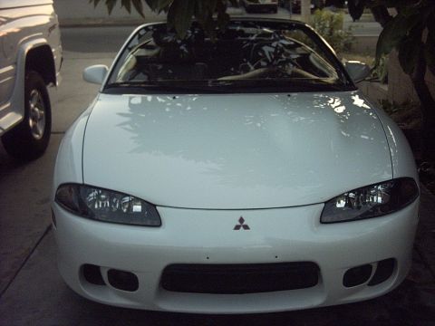 1998 Mitsubishi Eclipse - A white 1998 Mitsubishi Eclipse convertible is parked outside, with a portion of a white SUV visible on the left.