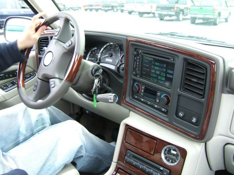 1998 Ford Taurus - The interior of a vehicle shows a dashboard and steering wheel, with trucks visible in the background.