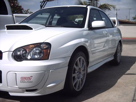 2005 Subaru Impreza - White 2005 Subaru Impreza WRX STI sedan, front 3/4 view, showing the distinctive hood scoop and STI badging.