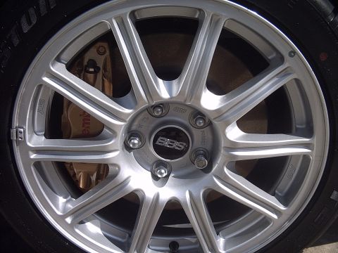 2005 Subaru Impreza - Close-up of a silver BBS wheel and gold Brembo brake caliper, with 'STi' branding on the wheel.