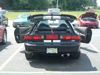 1997 Ford Probe - Rear view of a black sports car with its doors open, revealing the interior. A 'SUPERMOTORS' watermark is visible at the bottom.
