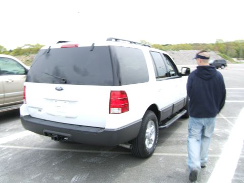 1998 Ford Taurus - A white Ford Expedition is seen from the rear in a parking lot, with a person walking away from the vehicle.