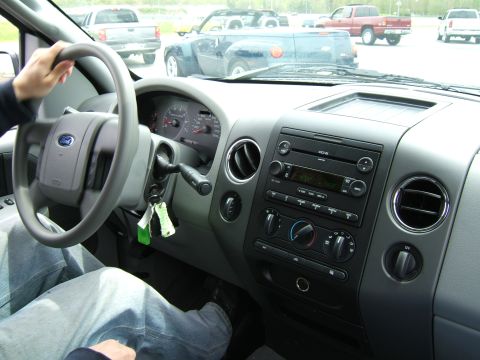1998 Ford Taurus - Interior of a pickup truck, showing the dashboard and steering wheel. Other vehicles are seen through the windshield.