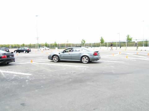1998 Ford Taurus - A gray sedan navigates a course marked by cones in an open lot.