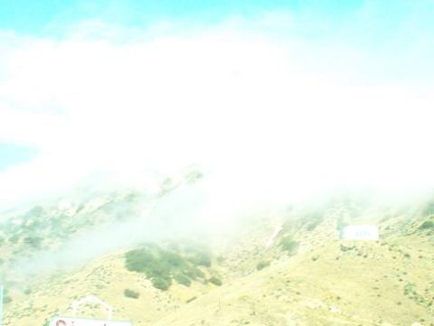 1988 Ford Bronco - A hazy mountain scene with clouds obscuring the upper portions of the hills.