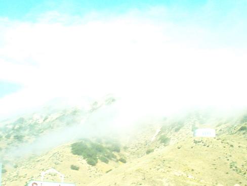 mountain landscape with clouds and a distant building