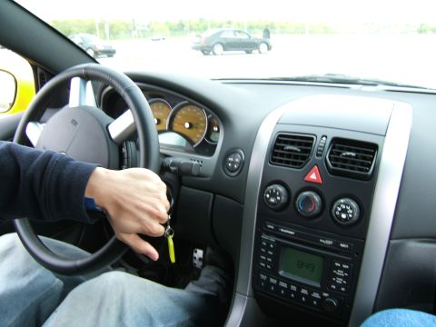 1998 Ford Taurus - Interior view of a car with a hand on the steering wheel and a view of other cars outside.