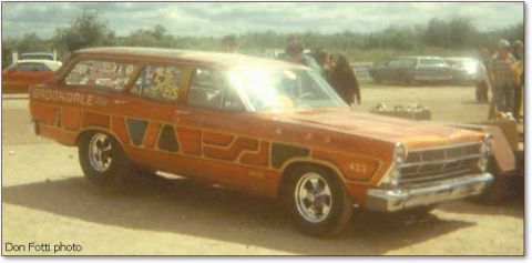 1967 Ford Fairlane - This vintage station wagon features custom graphics and racing numbers, with other vehicles and people in the background.