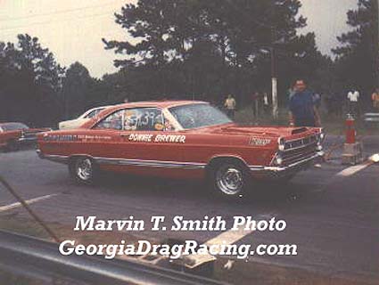 1967 Ford Fairlane - A red 1967 Ford Fairlane drag car, identified as belonging to Donnie Brewer, sits on the track.