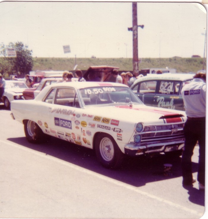 White vintage Ford drag coupe with sponsor decals at a drag strip