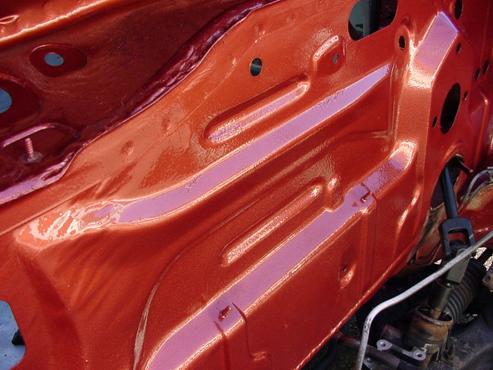 Orange painted engine bay structure with visible metal bracing and wiring