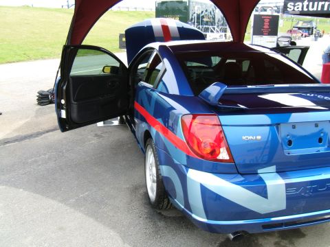 1998 Ford Taurus - A blue Saturn Ion with custom graphics and a spoiler is displayed with its driver's door open.