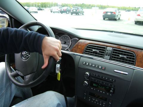 1998 Ford Taurus - Interior view of a car with a hand on the steering wheel, showing the dashboard and radio controls.