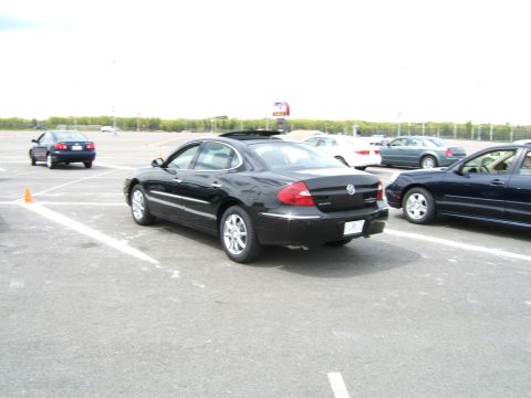 1998 Ford Taurus - A black Buick LaCrosse is parked in a lot with other vehicles visible.