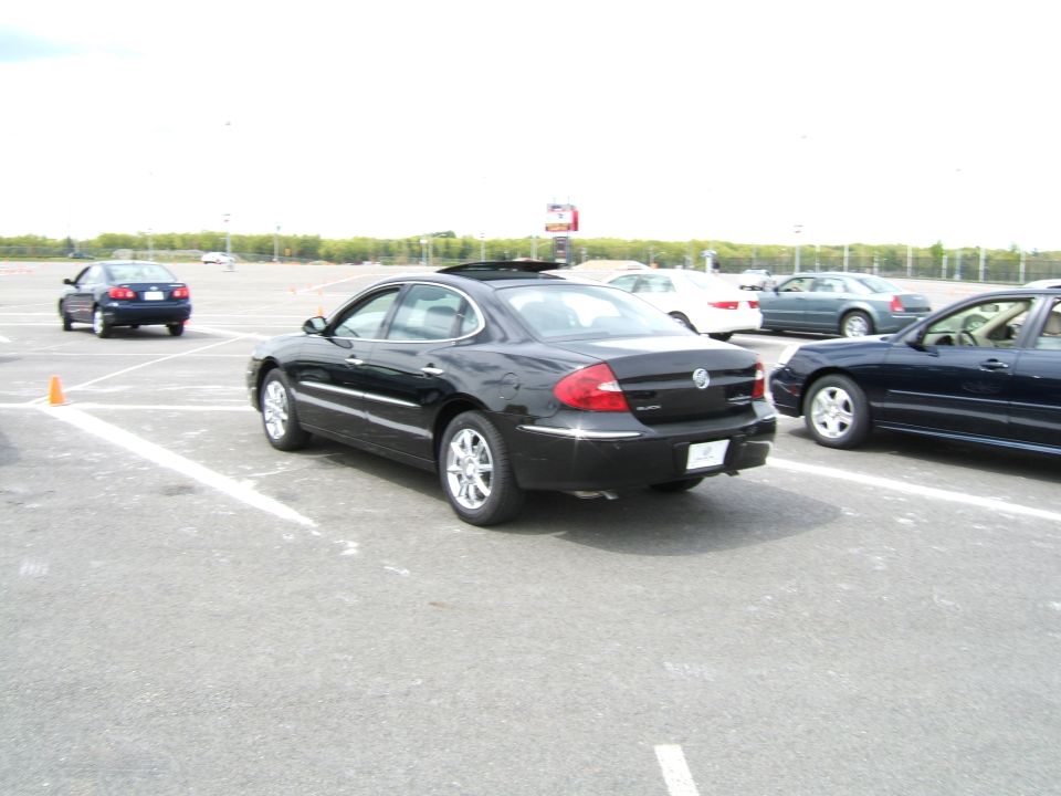Black Buick LaCrosse parked in lot, other cars around