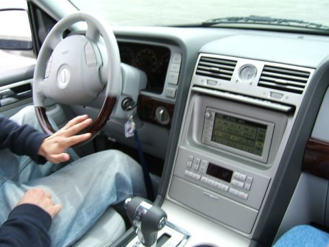 1998 Ford Taurus - The interior of a car shows the dashboard, steering wheel, and center console with the radio and climate controls.