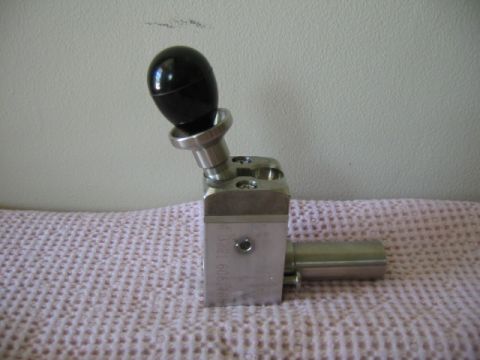 1992 Ford Bronco - A black shift knob is attached to a metal lever assembly, with some text visible on the side.