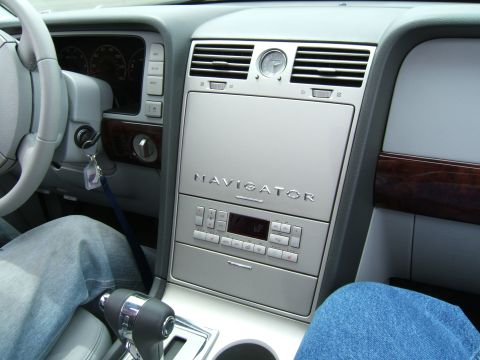 1998 Ford Taurus - The center console of a Lincoln Navigator features wood trim, a clock, and climate controls.