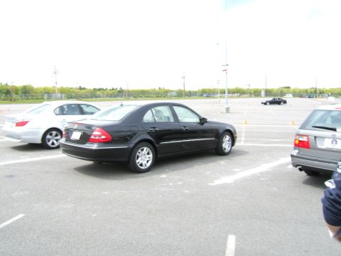 1998 Ford Taurus - A black Mercedes-Benz sedan is parked in a lot with other vehicles.