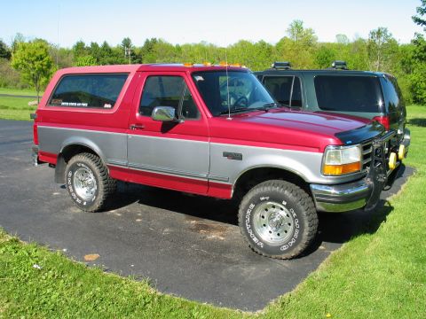 1995 Ford Bronco - 1995 Ford Bronco parked outside with a second vehicle in the background.