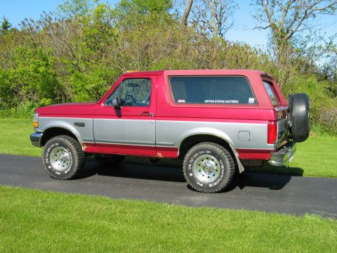 1995 Ford Bronco - This two-tone 1995 Ford Bronco features a removable red top and a spare tire carrier on the tailgate.