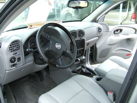 1998 Ford Taurus - Interior view of a Buick, a gray dashboard, steering wheel with Buick emblem, and light gray leather seats.