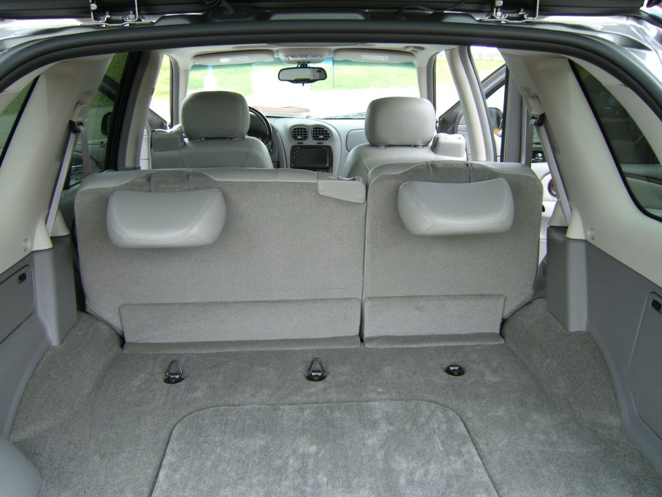 Interior view of an SUV cargo area showing folded rear seats and floor tie-down hooks